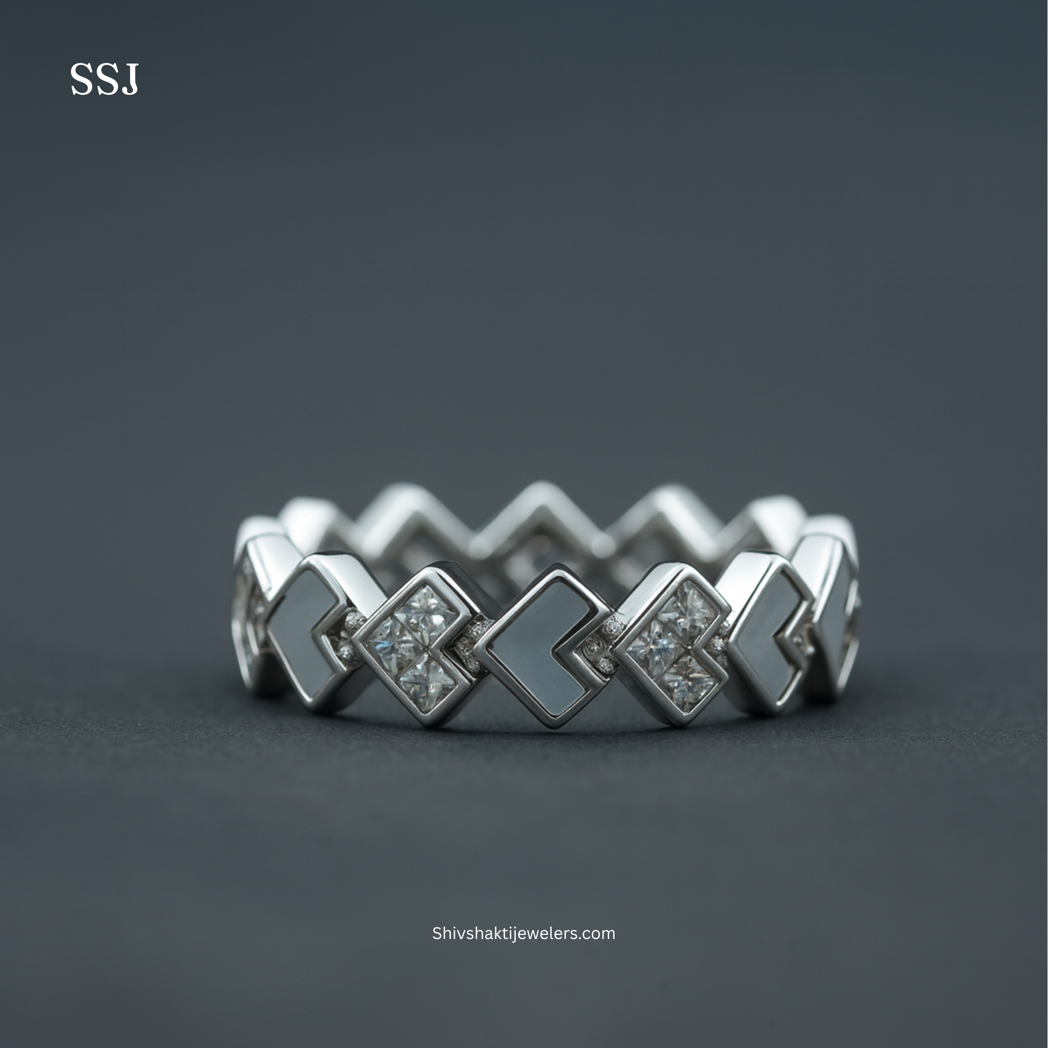 Silver ring with geometric design on a dark background