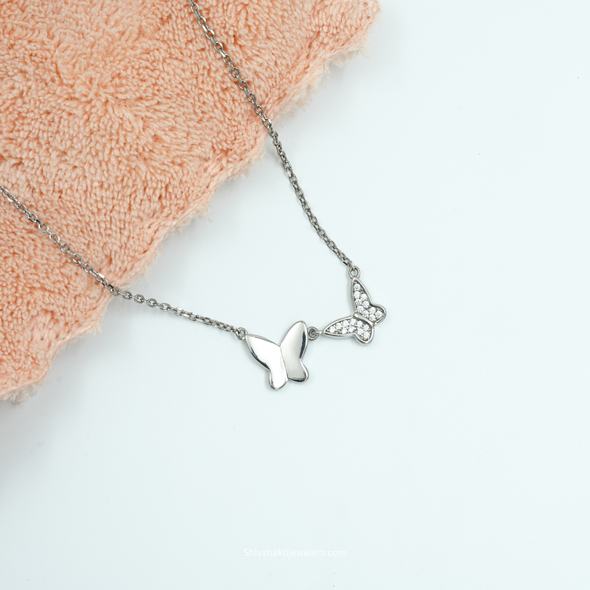 Close-up of 925 silver dual butterfly necklace with polished and CZ butterfly design