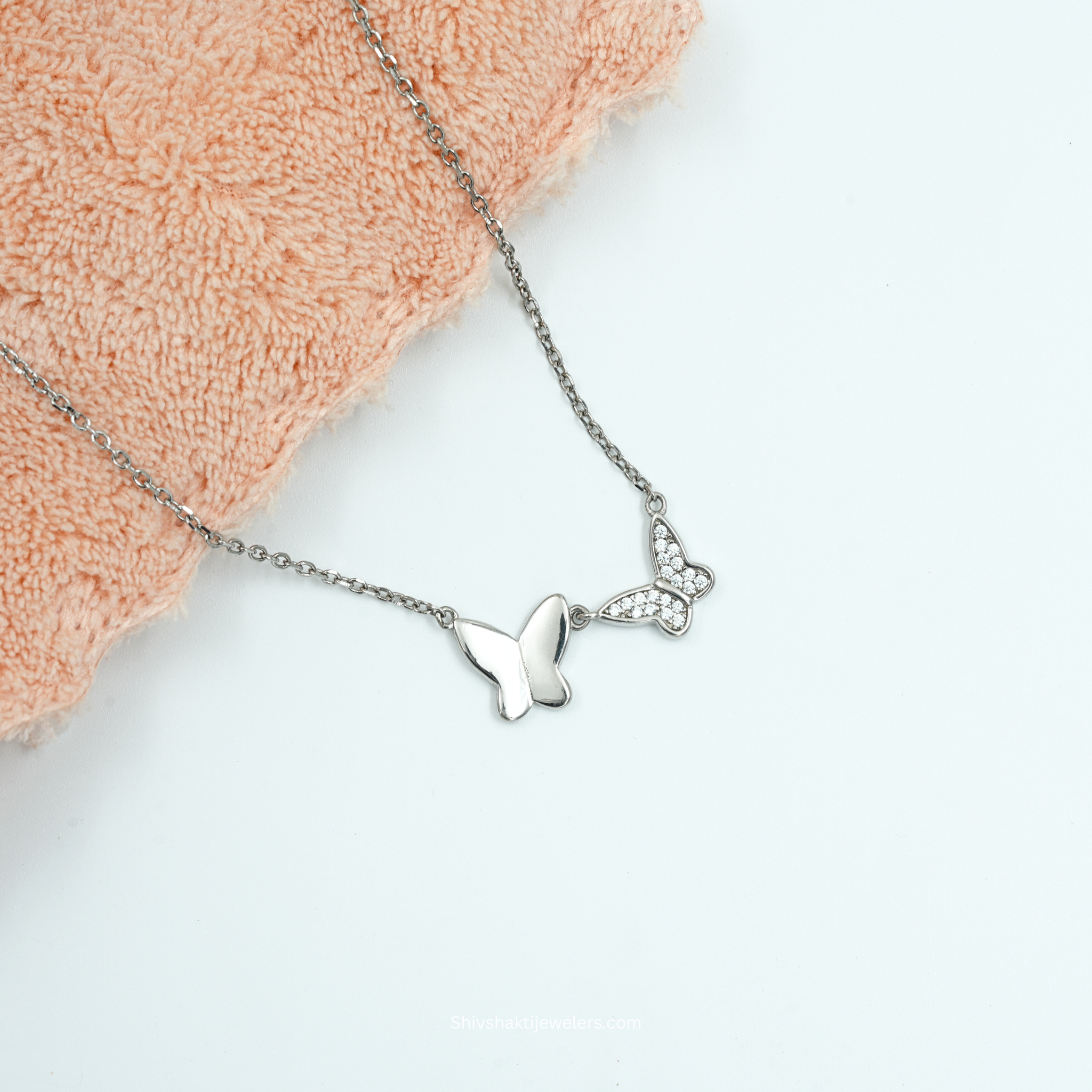 Close-up of 925 silver dual butterfly necklace with polished and CZ butterfly design