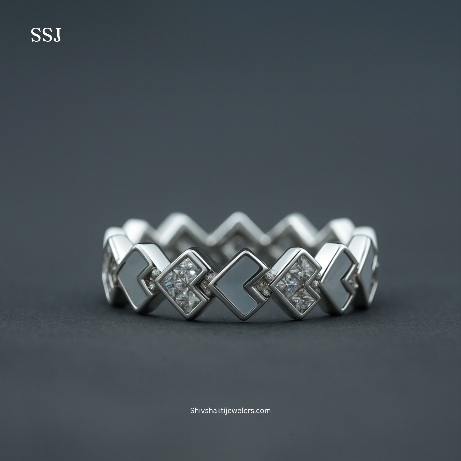 Silver ring with geometric design on a dark background