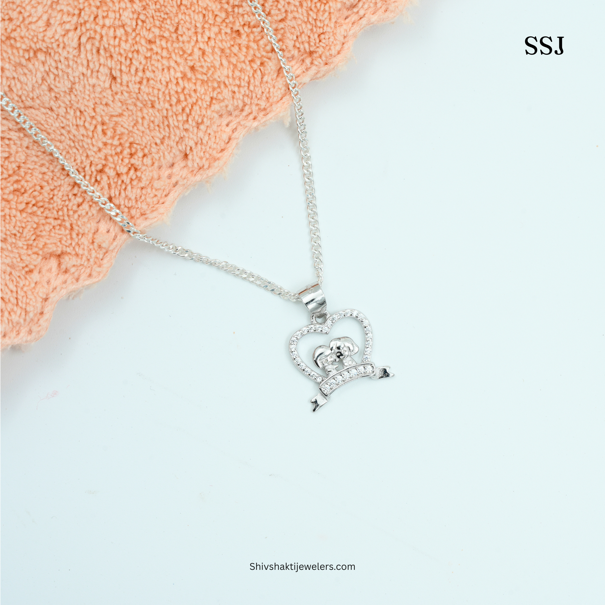 Silver necklace with a heart-shaped pendant on a white background