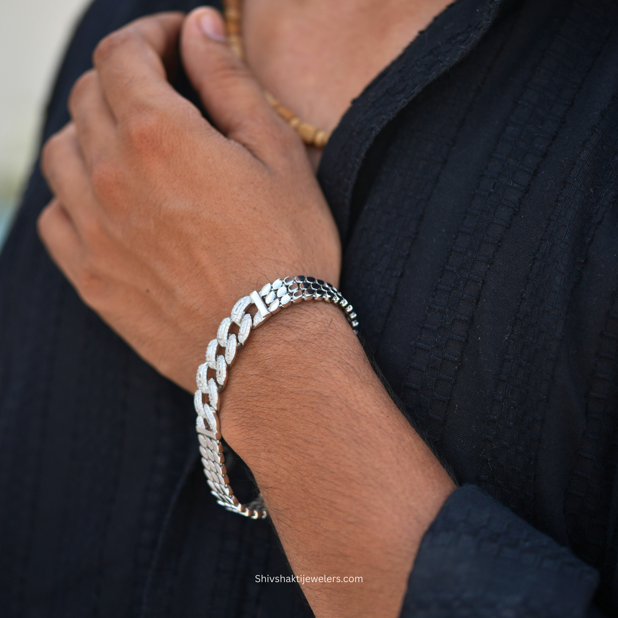 Silver chain bracelet on a wrist with a blurred background