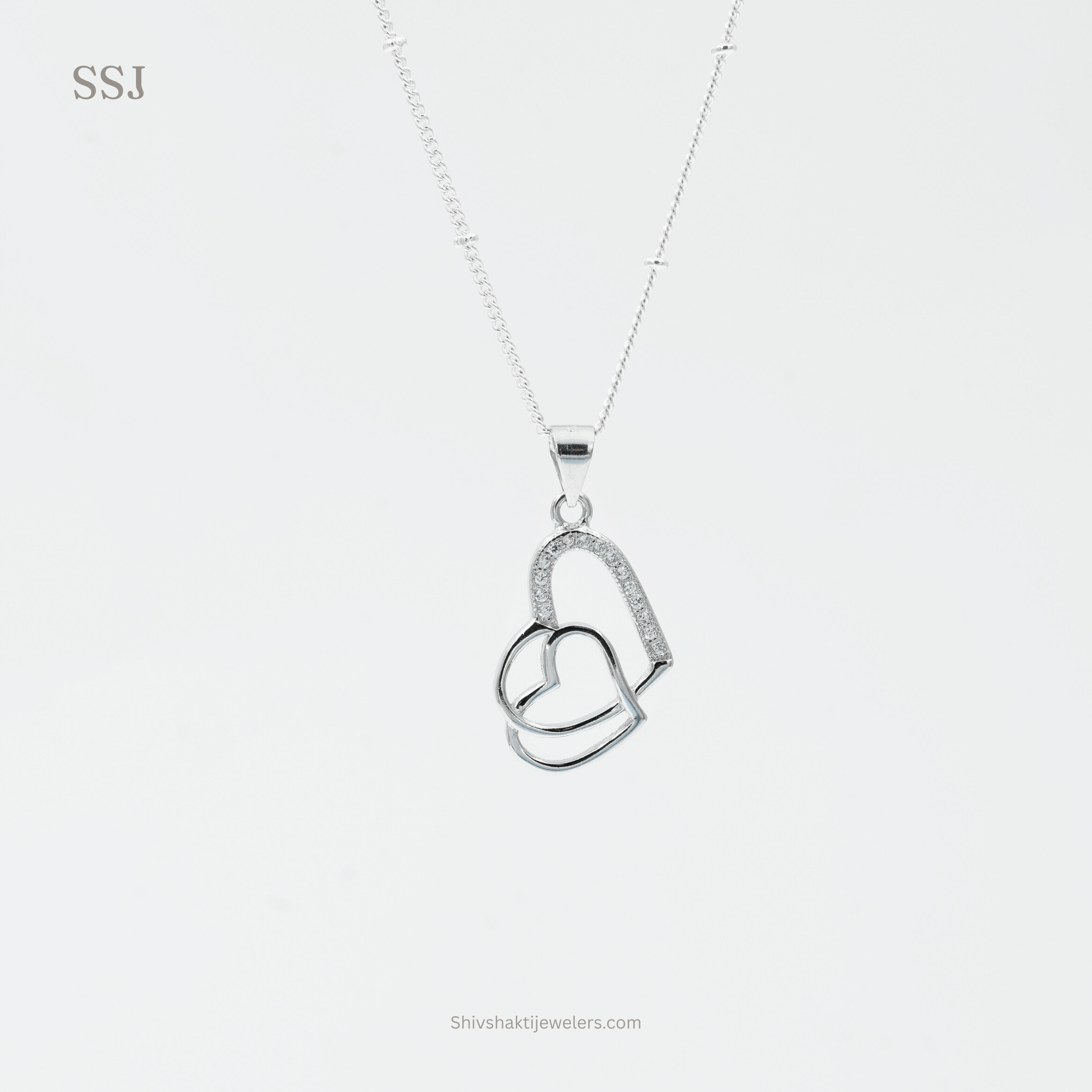 Silver necklace with a heart-shaped pendant on a white background