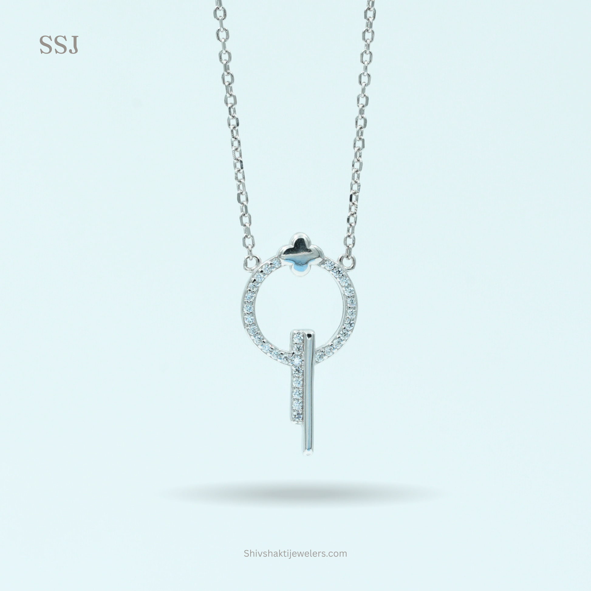 Silver necklace with a circular pendant and blue gemstone on a light gray background