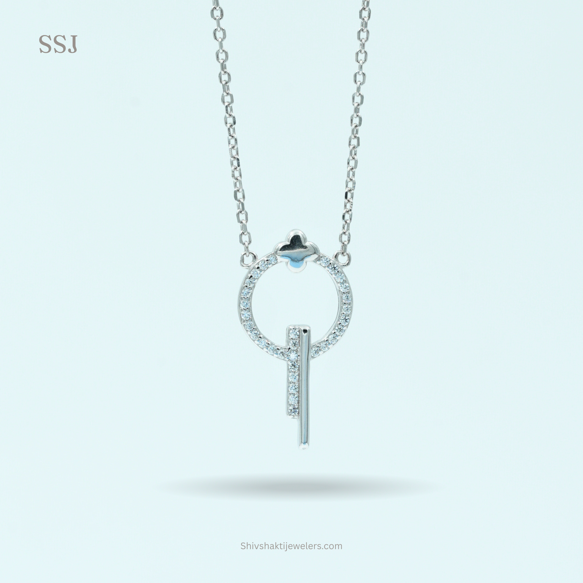 Silver necklace with a circular pendant and blue gemstone on a light gray background