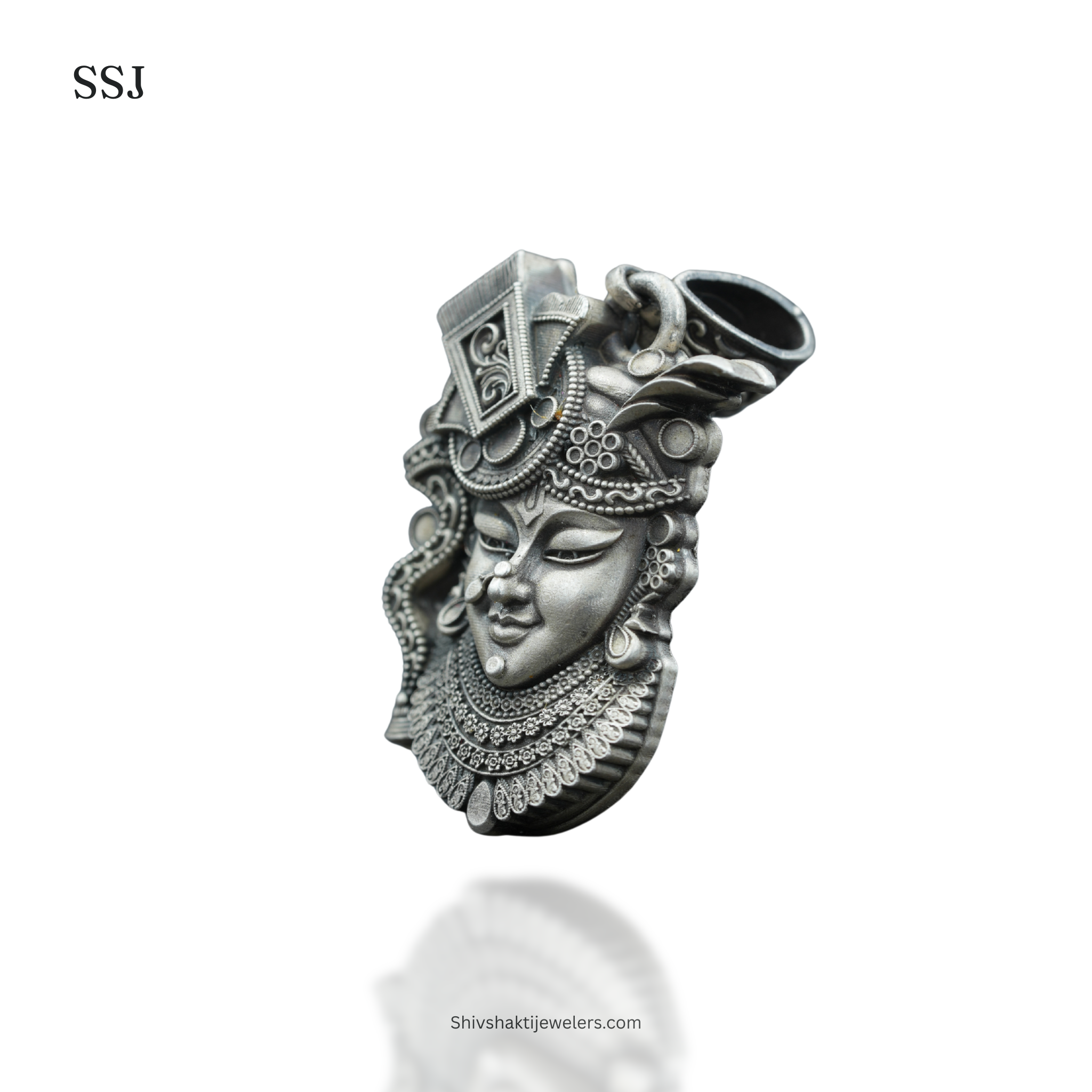 Silver pendant with intricate design on a white background