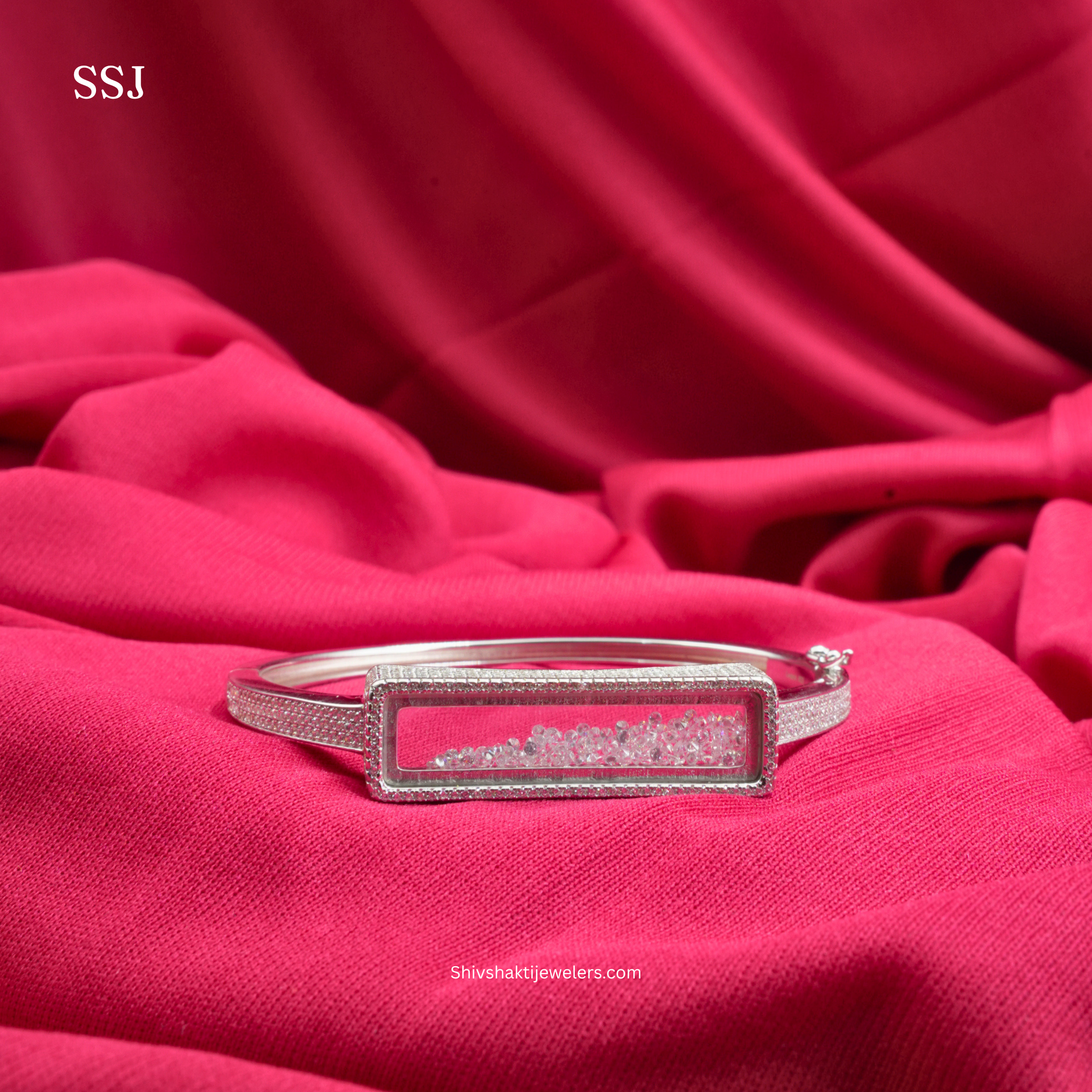 Silver bracelet with rectangular design on a red fabric background