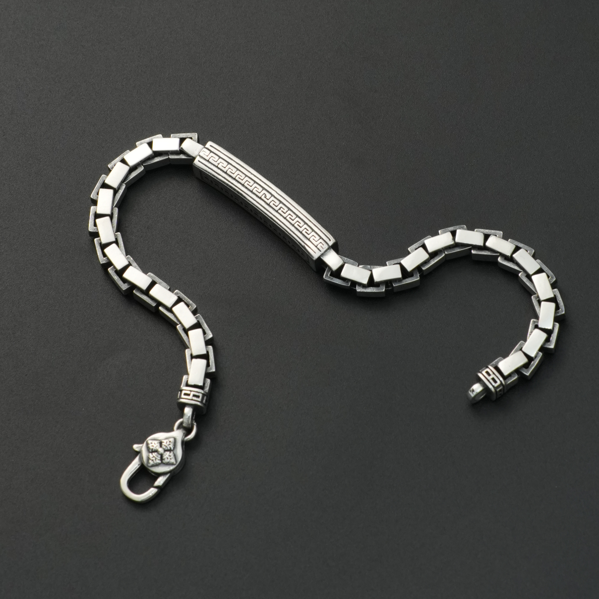 Silver bracelet on a dark gray background