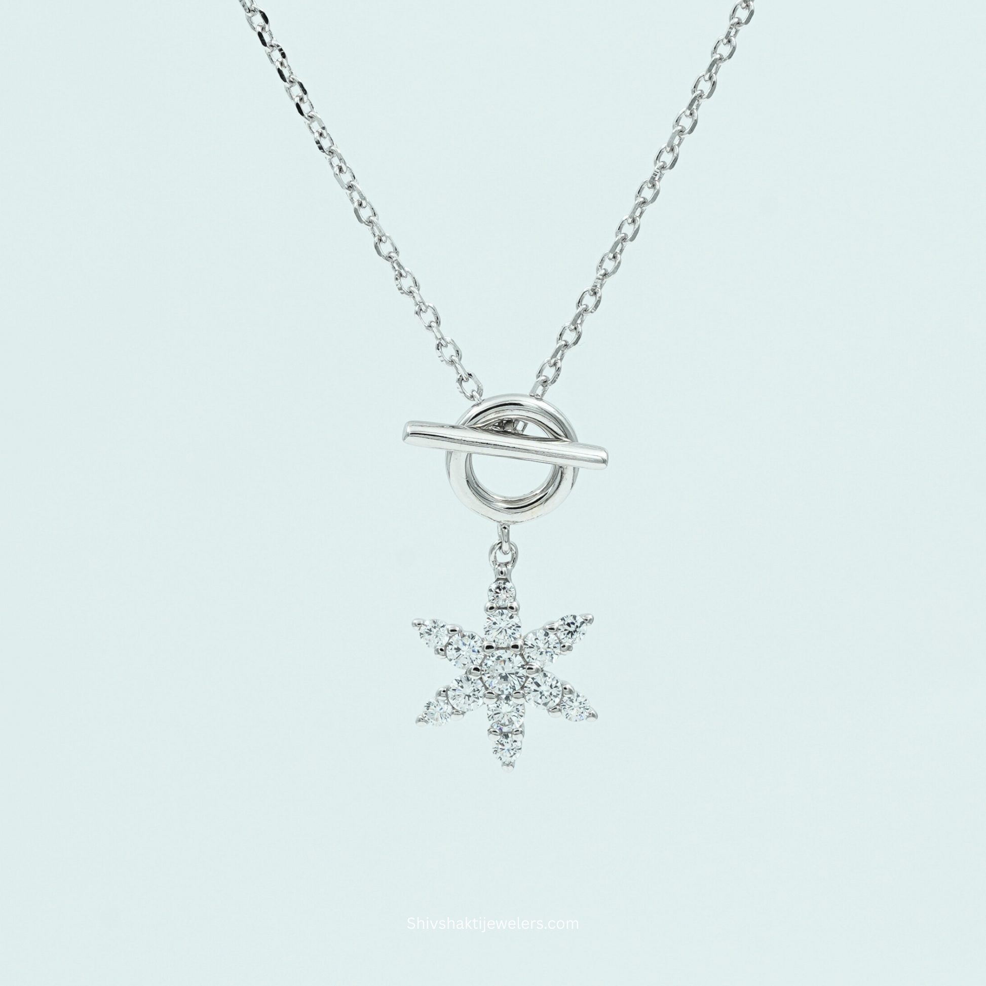 Silver necklace with a snowflake pendant on a light gray background