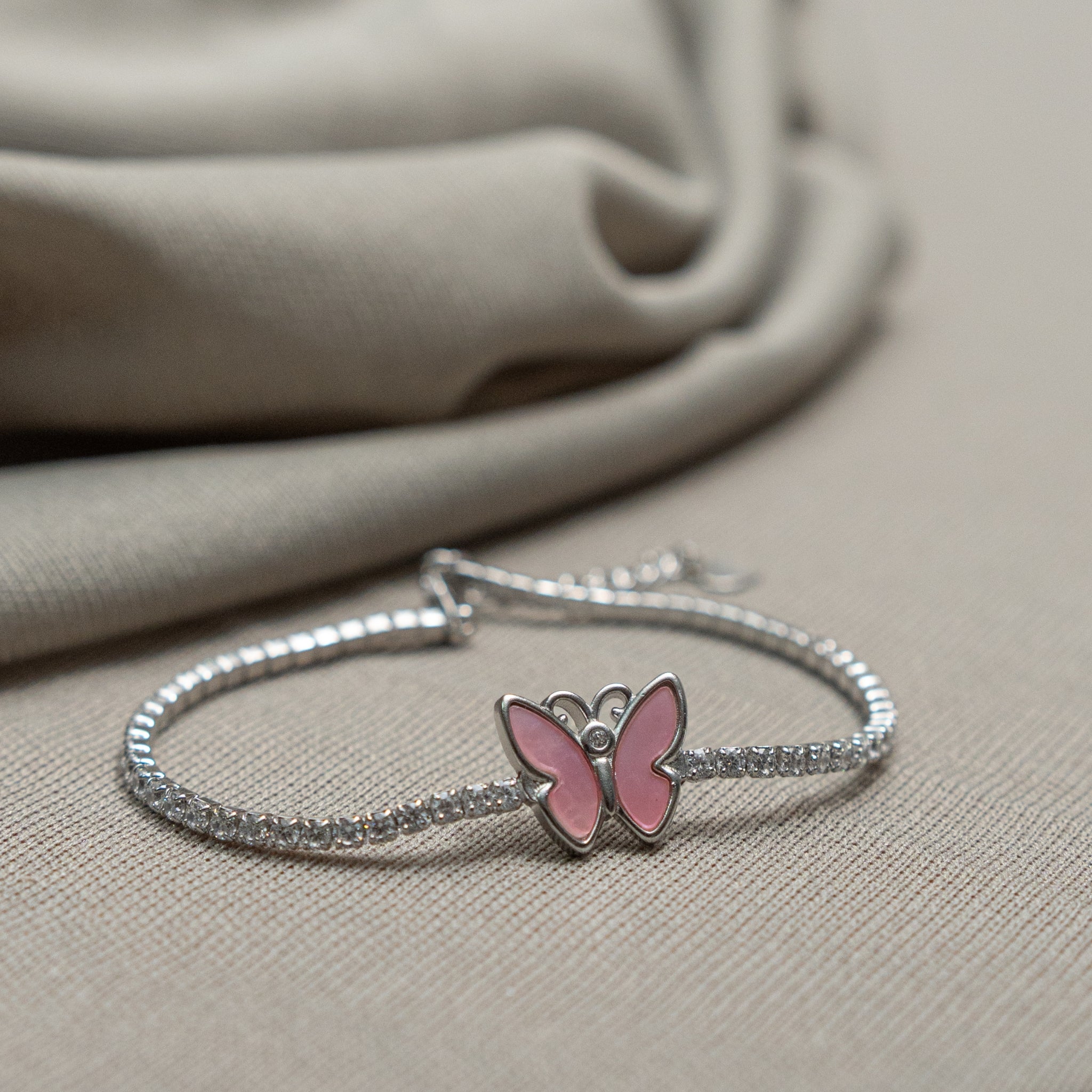 Pink butterfly 925 silver bracelet with CZ and enamel on beige background